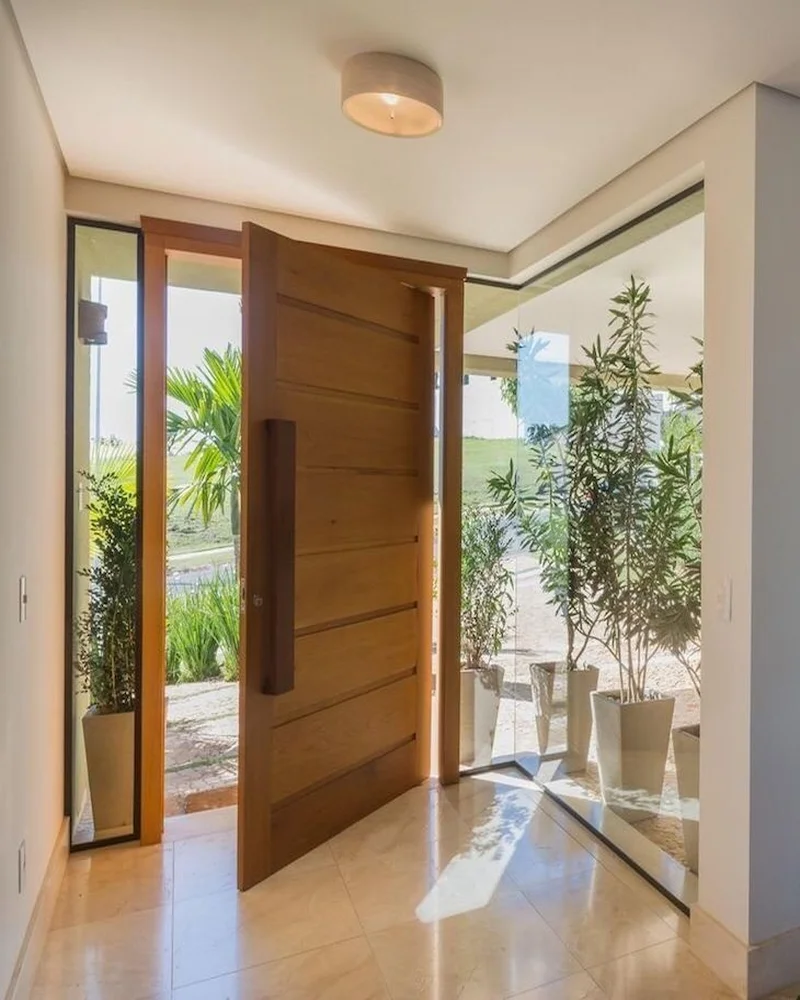 Puerta de madera arquitectónica con diseño moderno montada sobre quicio, ideal para proyectos residenciales premium o comerciales.