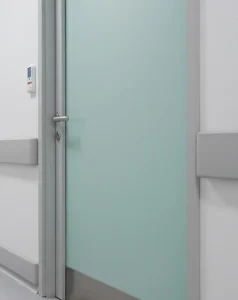 Puerta hospitalaria de alta durabilidad instalada en un pasillo de clínica o centro de salud, ideal para proyectos de infraestructura crítica. certificada con revestimiento HPL antibacterial, plomadas, acusticas e ignifugas